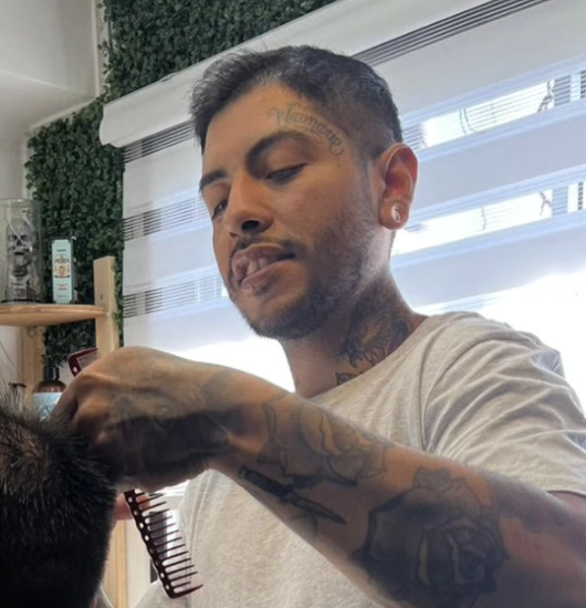 Hernan Castillo trabajando en un servicio de barberia